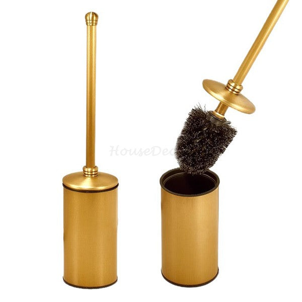 Gold-finished toilet brush set with a cylindrical holder and matching brush, shown with the brush lid off and the brush lifted out against a plain white background.